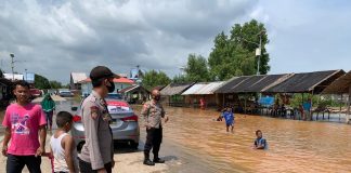 Kapolsek Kundur Utara Barat Kunjungi Wilayah Rawan Bencana untuk Beri Himbauan dan Informasi Penyelamatan Petugas kepolisian waktu memantau banjir di Kundur Utara Barat F,ist