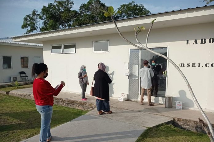 Petugas melakukan tes swab kepada warga untuk memastikan kesehatan F,ist