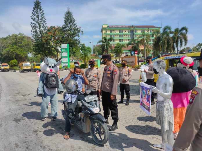 Jajaran Sat Binmas Polres Karimun Gandeng Badut dan Manusia Silver bagikan masker ke masyarakat F, ist