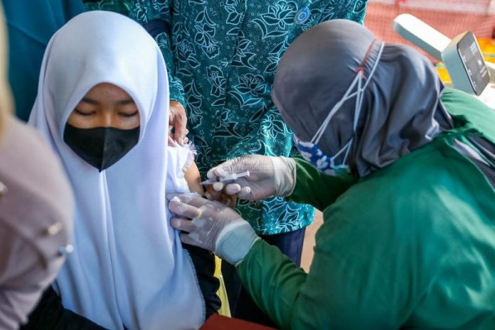 Petugas medis menyuntik vaksin kepada salah satu anak sekolah. Vaksinasi dianggap mampu menurunkan penyebaran covid-19 F,dok
