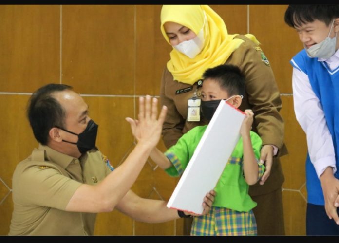 Dirjen Zudan Arif Fakrulloh menyerahkan secara simbolis dokumen kependudukan kepada siswa/i SLBN Cicendo Bandung, Senin (4/4/2022). Foto: Dok Dukcapil/Lukman