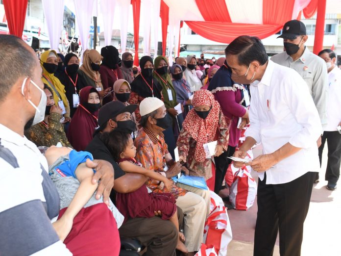 Presiden Jokowi didampingi Ibu Iriana Joko Widodo menyerahkan BMK dan BLT minyak goreng kepada peserta Program Keluarga Harapan (PKH) di Pasar Sungai Duri, Kabupaten Bengkayang, Provinsi Kalimantan Barat, pada Selasa (09/08/2022). (Foto: BPMI Setpres/Kris)