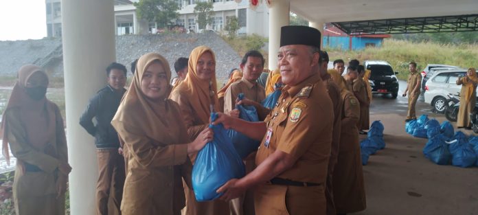 Pemerintah Kota Tanjungpinang memberikan bantuan sembako kepada 119 PTT dan THL di halaman Kantor Dinas Tenaga Kerja, Koperasi dan Usaha Mikro Kota Tanjungpinang, Selasa (21/03). F,Diskominfo Tanjungpinang