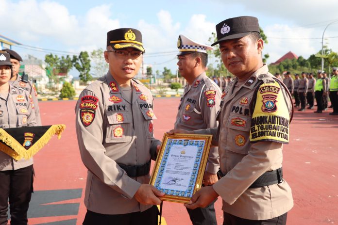 Kapolres Bintan AKBP Riky Iswoyo memberi penghargaan kepada dua orang Personil Polres Bintan yang berprestasi dalam upacara hari kesadaran Nasional yang dipimpin Kapolres Bintan, Jumat (17/3). f, Polres Bintan