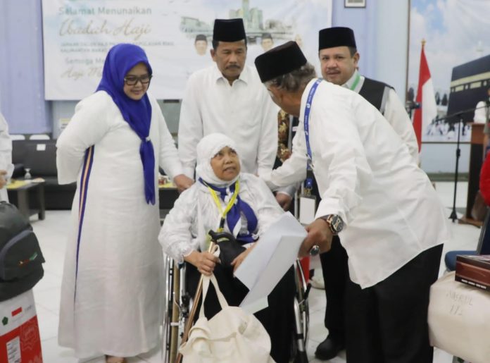 Wali Kota Batam/Kepala Badan Pengusahaan Batam H Muhammad Rudi (HMR), bersama Wakil Gubernur Kepulauan Riau Hj Marlin Agustina, ikut turun tangan membantu mendorong kursi roda seorang JCH perempuan asal Kota Tanjungpinang, hingga ke pintu keluar pemberangkatan, Kamis (25/5) F, Pemko Batam