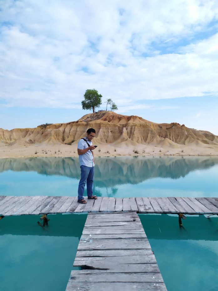 Seorang pengunjung saat berdiri di jembatan telaga biru yang terdapat di Gurun Pasir Bintan. Tempat ini menjadi salah satu kawasan pariwisata di Bintan f,BI