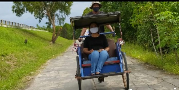 Seorang wisatawan ketika menggunakan becak dayung mengelilingi Pulau Penawar Rindu. Pulau yang memiliki kuliner yang nikmat dan sejarah ini menjadi tempat wisata yang sering dikunjungi di Pulau Batam f,BI