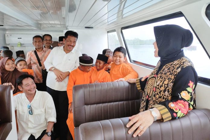 Menteri Sosial (Mensos), Tri Rismaharini, Wali Kota Batam, Muhammad Rudi dan para anak sekolah langsung mencoba kapal bantuan yang diberikan untuk membantu anak sekolah di Pulau Bertam, Jumat (20/10) f,Pemko Batam