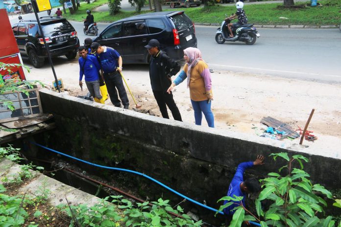 Penjabat Sementara (Pjs) Wali Kota Batam, Andi Agung, turun langsung dalam kegiatan gotong-royong bersama seluruh Organisasi Perangkat Daerah (OPD) di lingkungan Pemerintah Kota (Pemko) Batam ke sejumlah titik yang terdampak banjir, diantaranya Happy Garden, SP Plaza, dan Seruni, Jumat Pagi (18/10/2024). f,Pemko Batam