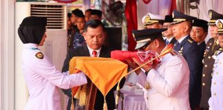Sang Merah Putih Diturunkan, Nyanyang Titip Pesan untuk Generasi Penerus Bangsa Wakil Gubernur Kepri, Nyanyang Haris Pratamura mencium bendera merah putih yang diserahkan Nurjihan Dwi Hanifah, Paskibraka yang bertugas membawa baki pada Upacara Penurunan Bendera Peringatan HUT ke-81 di Gedung Daerah, Tanjungpinang, Senin (17/8/2026). (Enji/DISKOMINFO KEPRI)